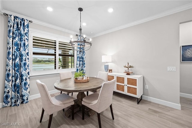 dining room with ornamental molding, an inviting chandelier, and light hardwood / wood-style floors