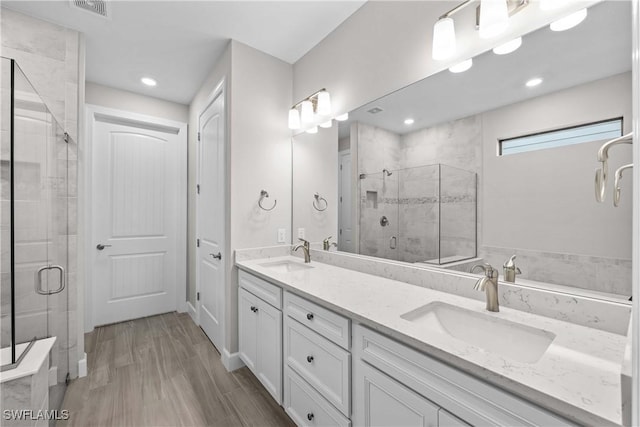 bathroom with vanity, hardwood / wood-style floors, and a shower with door