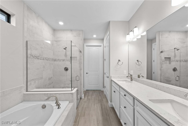 bathroom with vanity and shower with separate bathtub