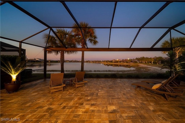 patio terrace at dusk with glass enclosure and a water view