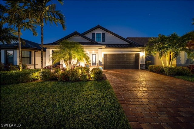 view of front of property with a garage and a yard