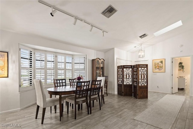 dining space featuring a chandelier, track lighting, and a skylight