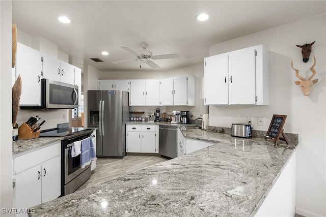 kitchen featuring sink, light stone counters, ceiling fan, stainless steel appliances, and white cabinets