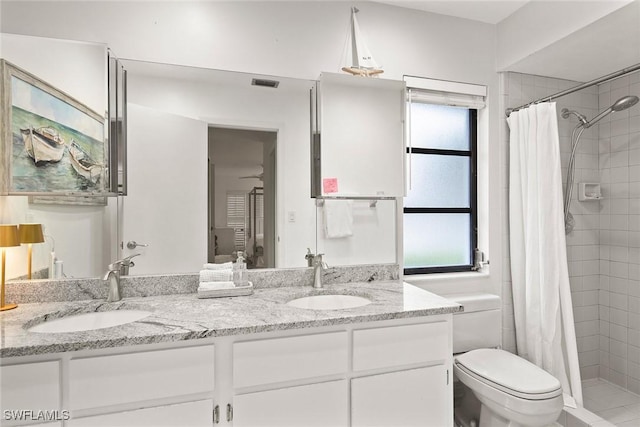 bathroom featuring vanity, toilet, a healthy amount of sunlight, and walk in shower