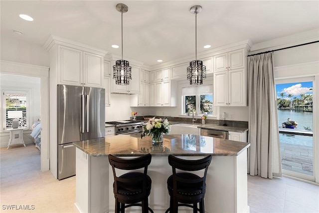 kitchen with high quality appliances, white cabinetry, a kitchen island, and pendant lighting