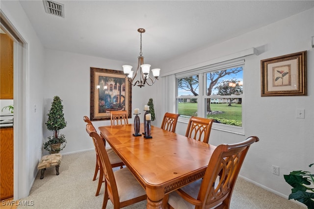 dining space featuring light colored carpet and a notable chandelier