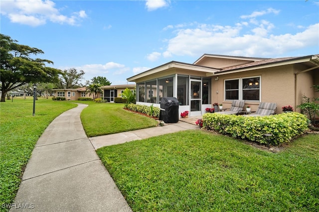 ranch-style home with a front lawn and a sunroom