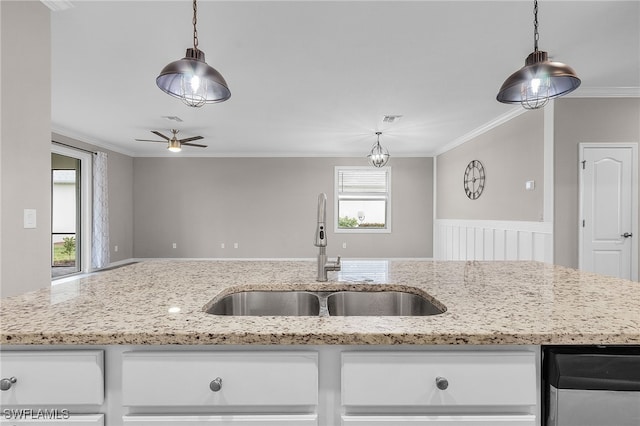 kitchen with sink, light stone counters, white cabinets, and pendant lighting