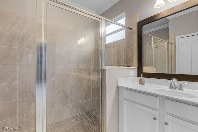 bathroom with crown molding, a shower with shower door, and vanity