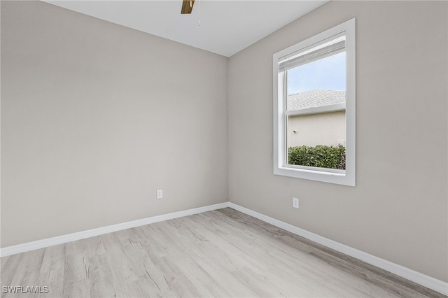 empty room featuring ceiling fan, a wealth of natural light, and light hardwood / wood-style flooring