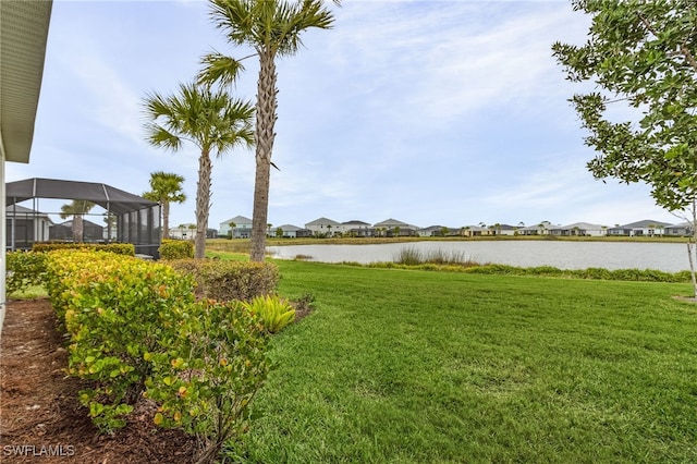 view of yard featuring a lanai and a water view