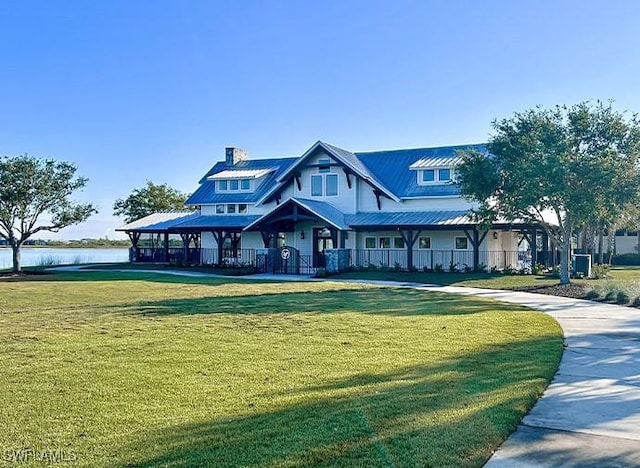 view of front of property with a water view and a front lawn