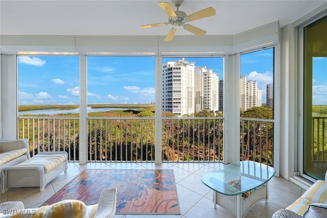 unfurnished sunroom with a water view and ceiling fan