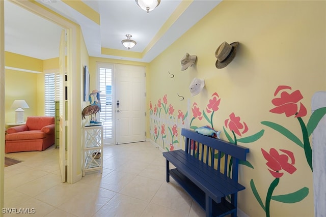 tiled entryway with a raised ceiling