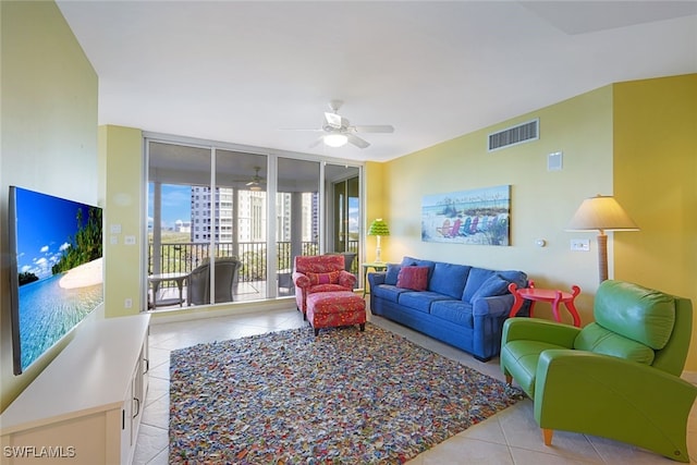 tiled living room featuring ceiling fan and a wall of windows