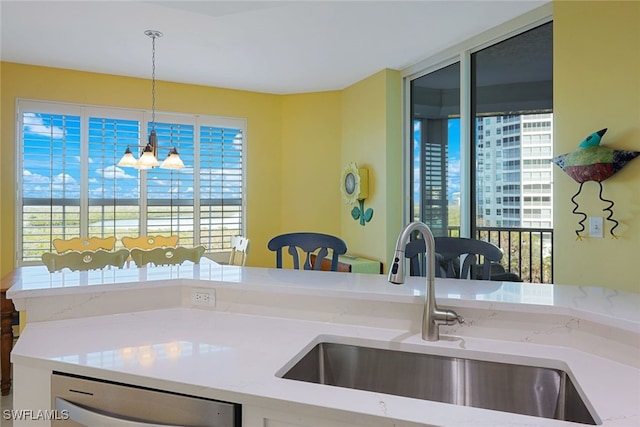 kitchen featuring sink, decorative light fixtures, stainless steel dishwasher, and a healthy amount of sunlight