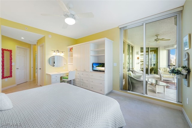 carpeted bedroom featuring ceiling fan, built in desk, and multiple closets