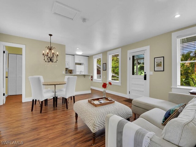 living room featuring wood-type flooring and an inviting chandelier