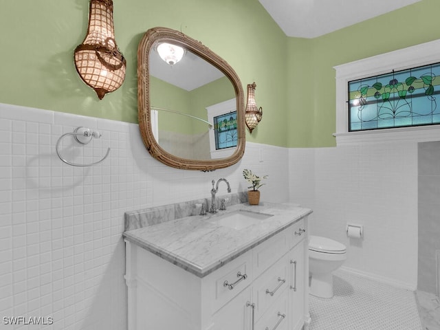 bathroom featuring tile patterned flooring, vanity, tile walls, and toilet