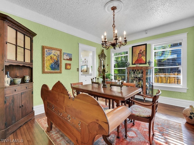 dining area with plenty of natural light, a notable chandelier, and dark hardwood / wood-style flooring