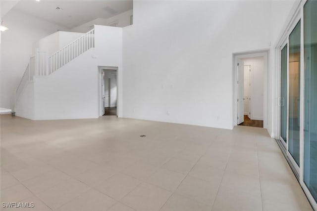 unfurnished living room with a towering ceiling