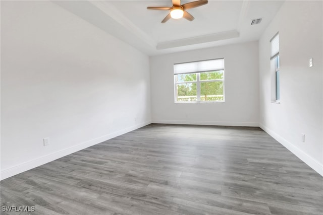spare room featuring ceiling fan, a raised ceiling, and hardwood / wood-style floors