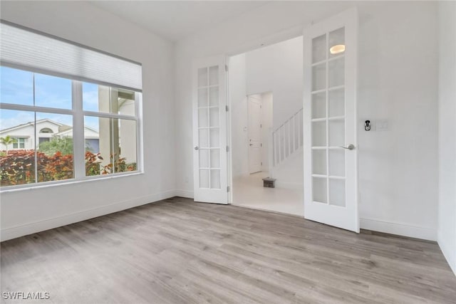 empty room featuring light hardwood / wood-style floors and french doors