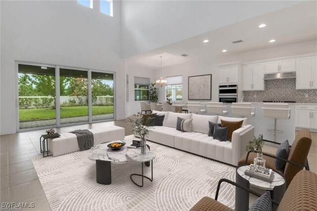 living room with an inviting chandelier, a high ceiling, and light tile patterned floors