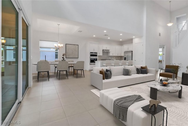 living room featuring a high ceiling, light tile patterned floors, and an inviting chandelier