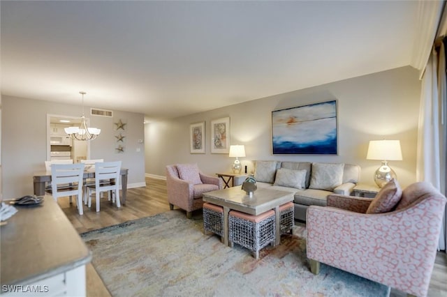 living room with a notable chandelier and hardwood / wood-style flooring