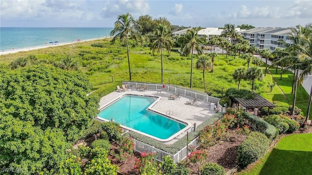 view of pool featuring a view of the beach, a patio area, and a water view