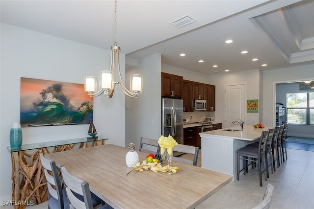 dining space featuring sink, light tile patterned floors, and crown molding