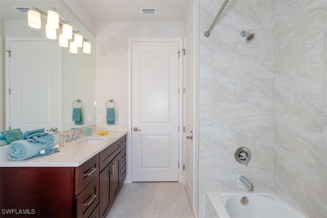 bathroom featuring tiled shower / bath combo and vanity