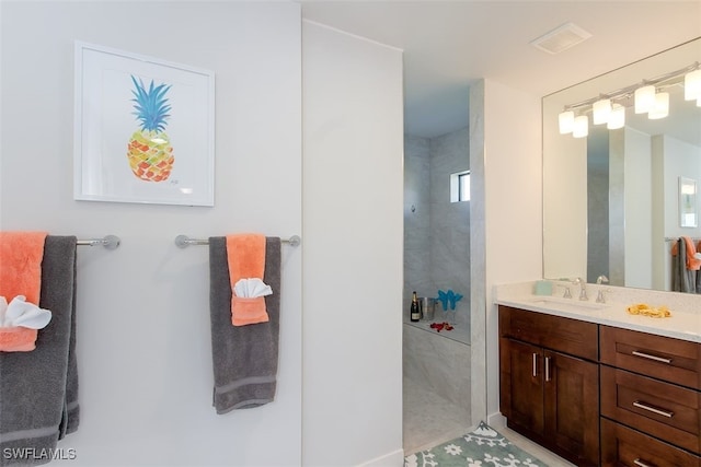 bathroom featuring vanity, tile patterned floors, and tiled shower