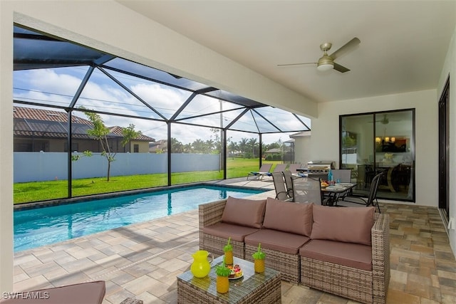 view of swimming pool featuring ceiling fan, a patio area, a yard, glass enclosure, and an outdoor hangout area