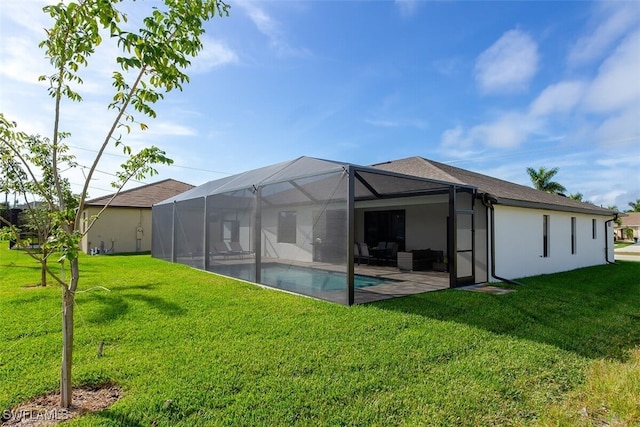 rear view of house with a patio area, a lanai, and a lawn