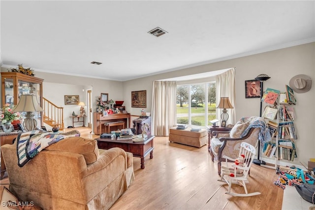 living room featuring ornamental molding and light hardwood / wood-style flooring