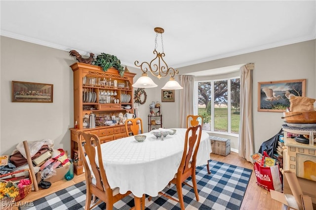 dining area with crown molding and light hardwood / wood-style floors