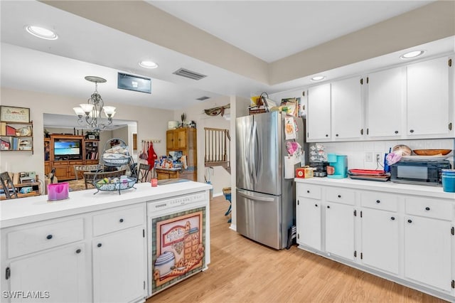 kitchen with pendant lighting, white cabinetry, light hardwood / wood-style floors, backsplash, and stainless steel fridge