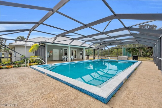 view of pool with glass enclosure, a patio area, and a hot tub