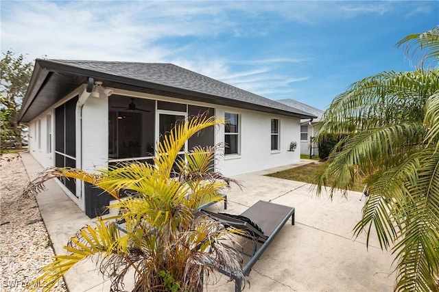 rear view of property featuring ceiling fan and a patio