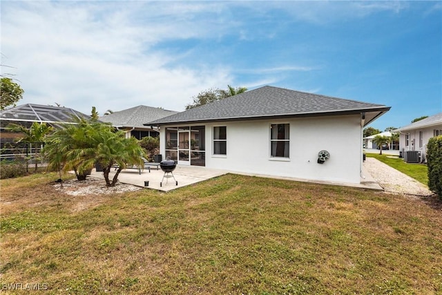 back of house featuring a sunroom, cooling unit, a lawn, and a patio