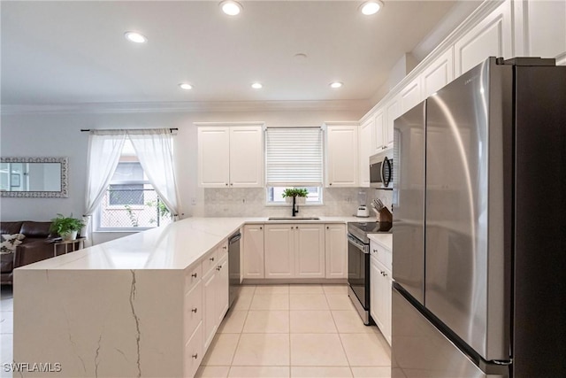 kitchen featuring white cabinetry, stainless steel appliances, backsplash, ornamental molding, and sink