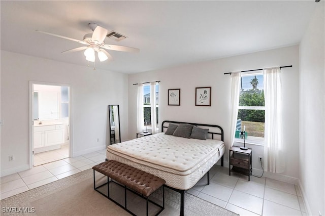 bedroom featuring ceiling fan, light tile patterned floors, and ensuite bath