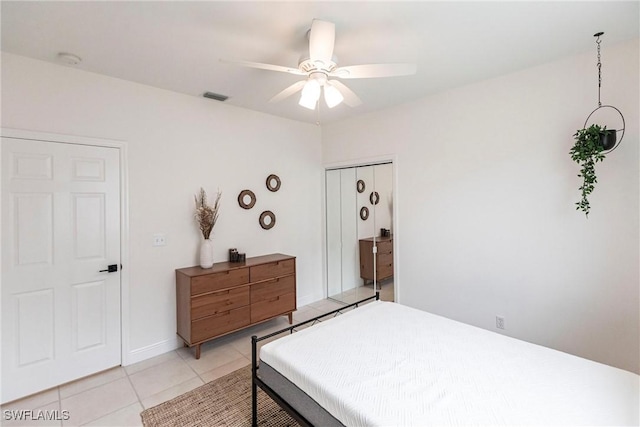 bedroom with ceiling fan, light tile patterned floors, and a closet