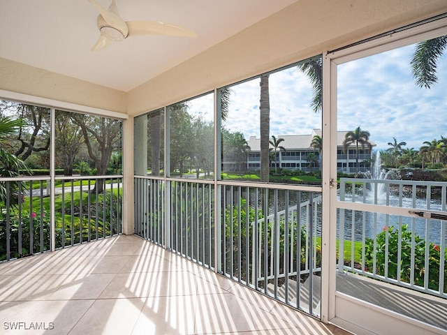 unfurnished sunroom featuring a water view and ceiling fan