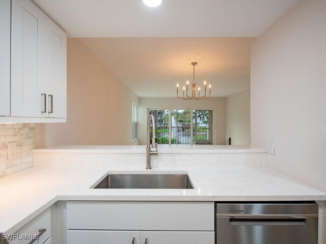 kitchen with hanging light fixtures, white cabinetry, sink, and stainless steel dishwasher