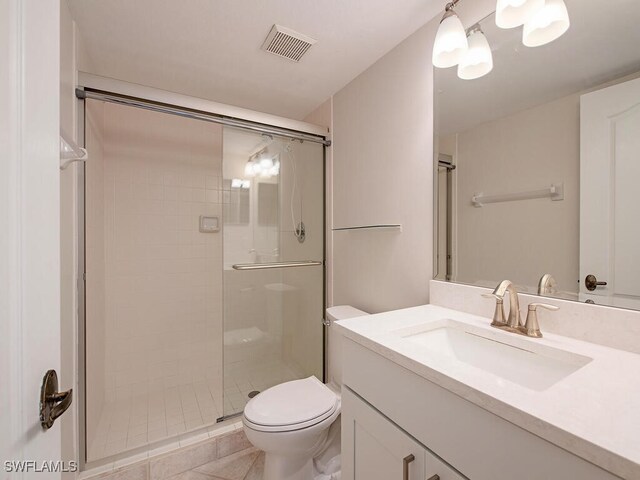 bathroom with vanity, a shower with shower door, tile patterned floors, and toilet