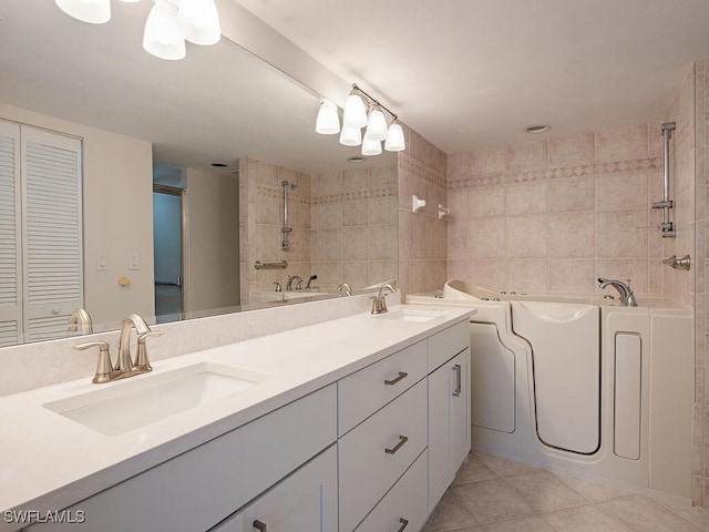 bathroom featuring tile patterned floors, a bathtub, tile walls, and vanity