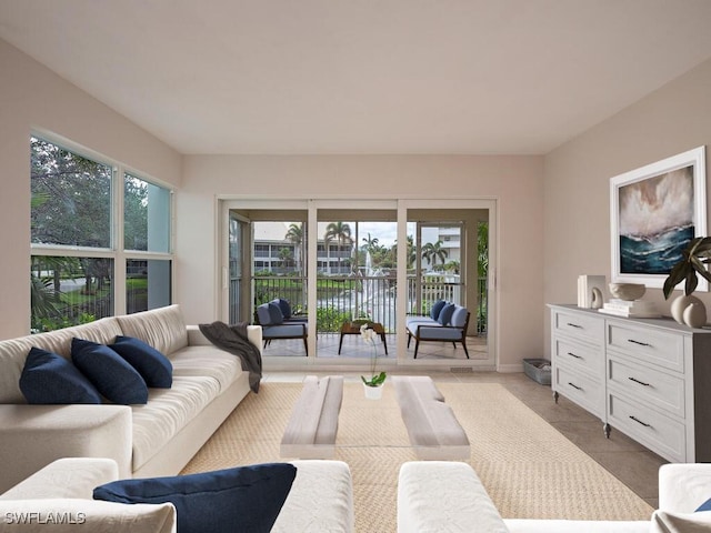 living room with a wealth of natural light, light tile patterned flooring, and a water view